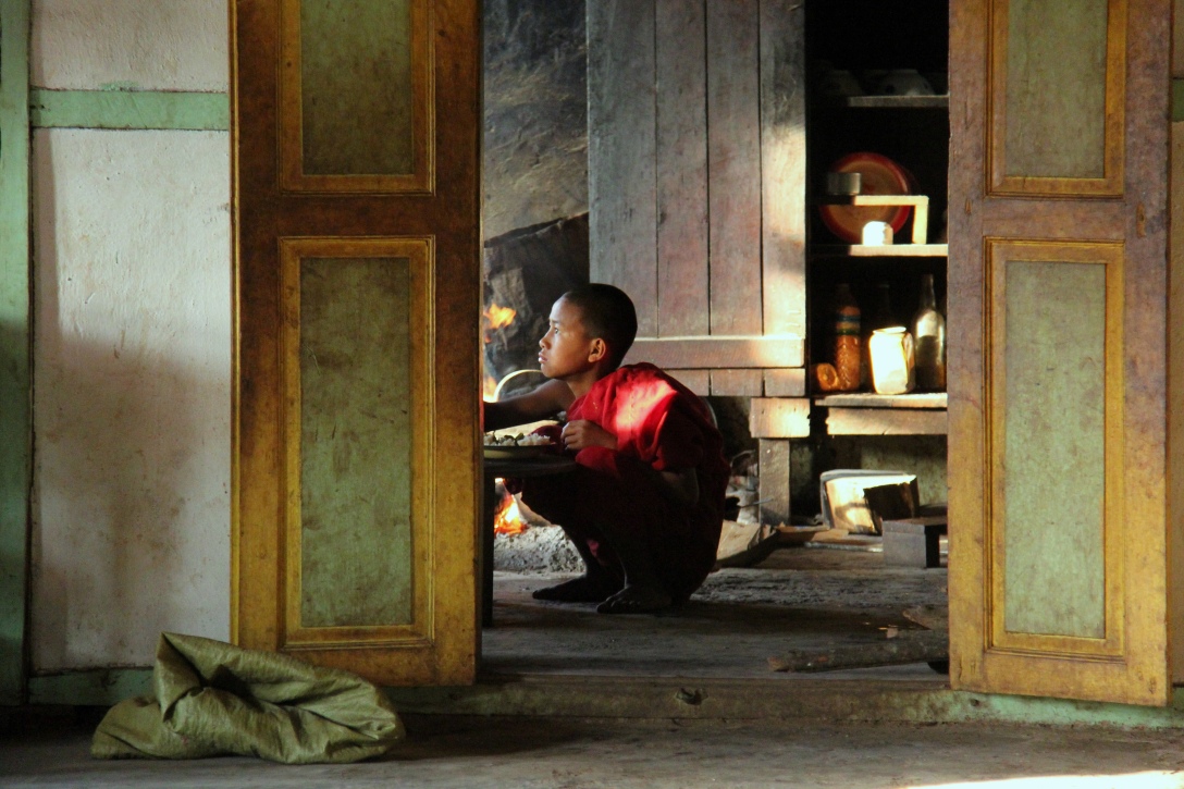 little monk eating dinner at the monastery next door